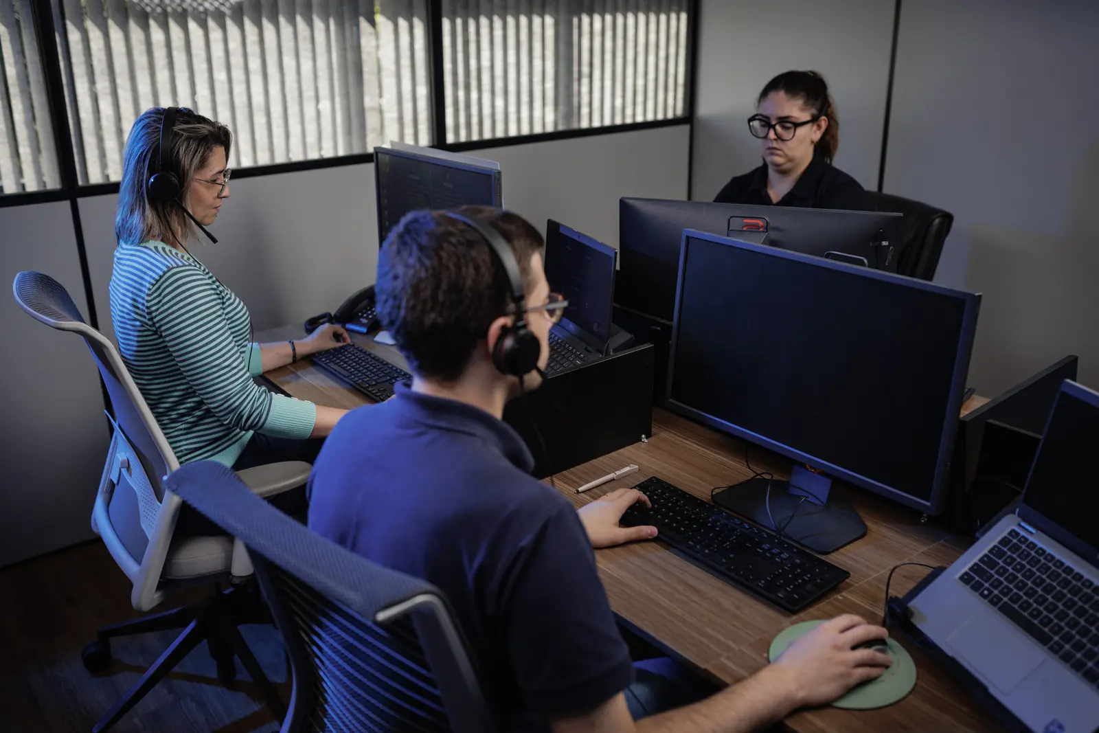 Equipe corporativa trabalhando em estações com computadores